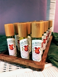 Multiple roll-on jars on a wooden holder. The jars contain a rosemary jojoba mixture.