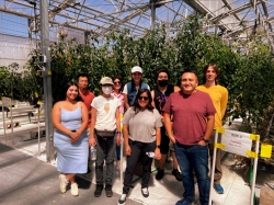 workshop attendees line up for a photo in front of tomato plants.