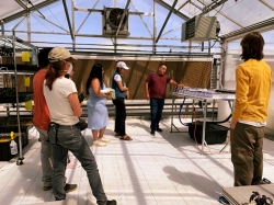 attendees at a workshop stand inside a greenhouse 