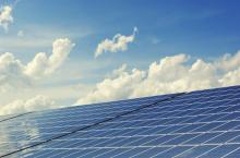 Solar panels against a partly cloudy blue sky. 