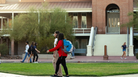students walk on paths in front of Old Main