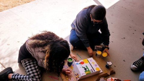 Two students painting a project