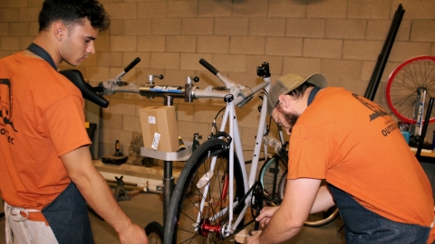 campus bike shop initiative with two people fixing a bike