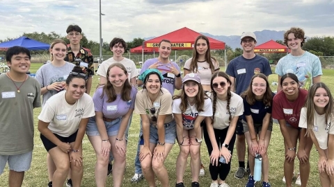 A large group of students stand together smiling at the camera.